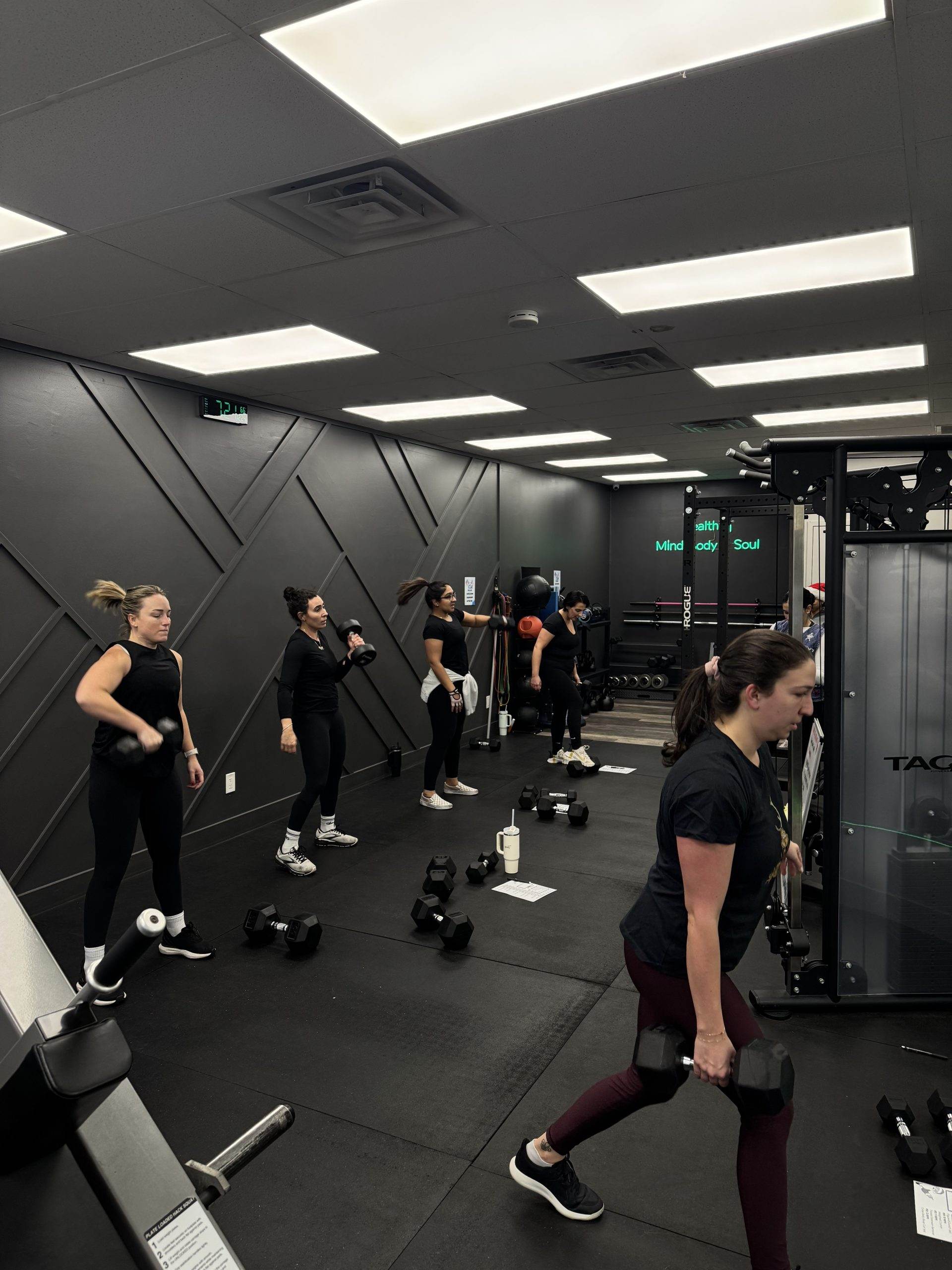 Members pressing dumbbells in a coached small group at Balanced Health Fitness in Seaford, NY.